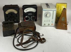 A collection of early 20th century bakelite volt meters, together with a RF signal generator,