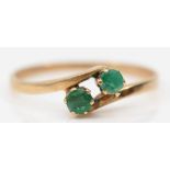 A 9ct gold two stone emerald dress ring, P-Q, 1.2gm.