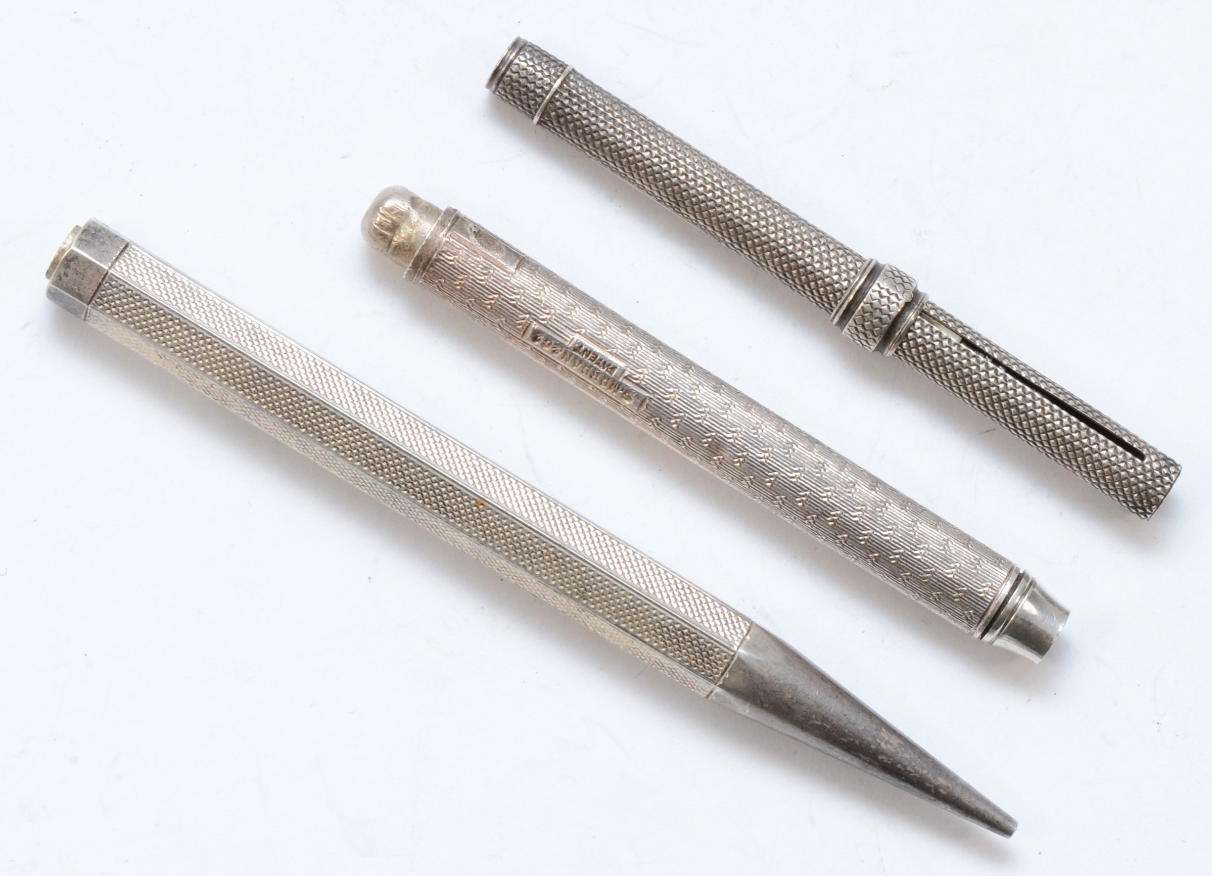 Three silver propelling pencil bodies to include a engine turned example, London 1934, 10cm.