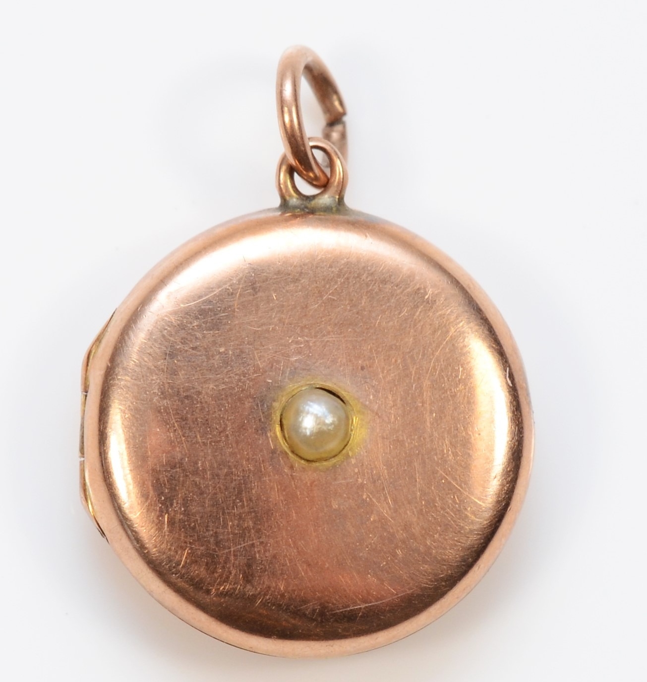 A 9ct gold front and back sead pearl circular locket, 15mm, 2.1gm.