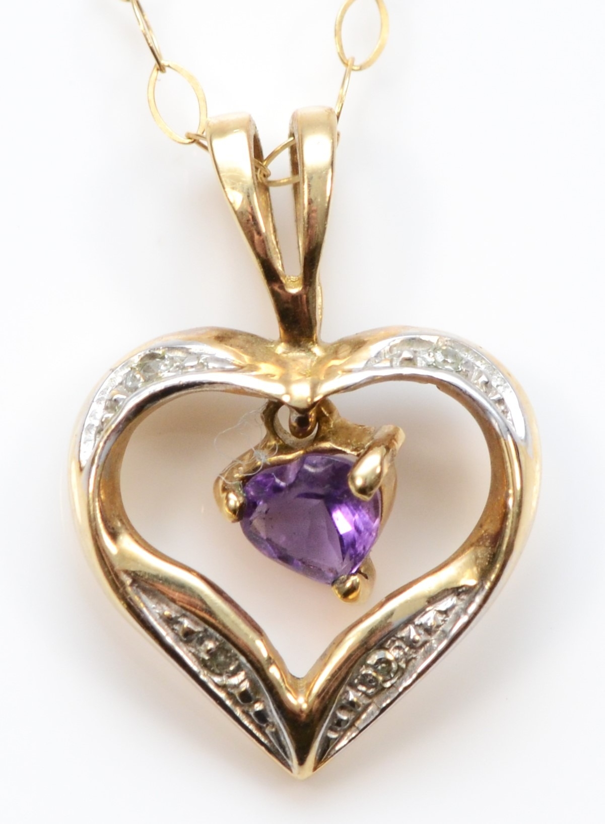 A gold amethyst and eight cut diamond heart pendant, unmarked, on a 375 gold chain, 17 x 12mm,