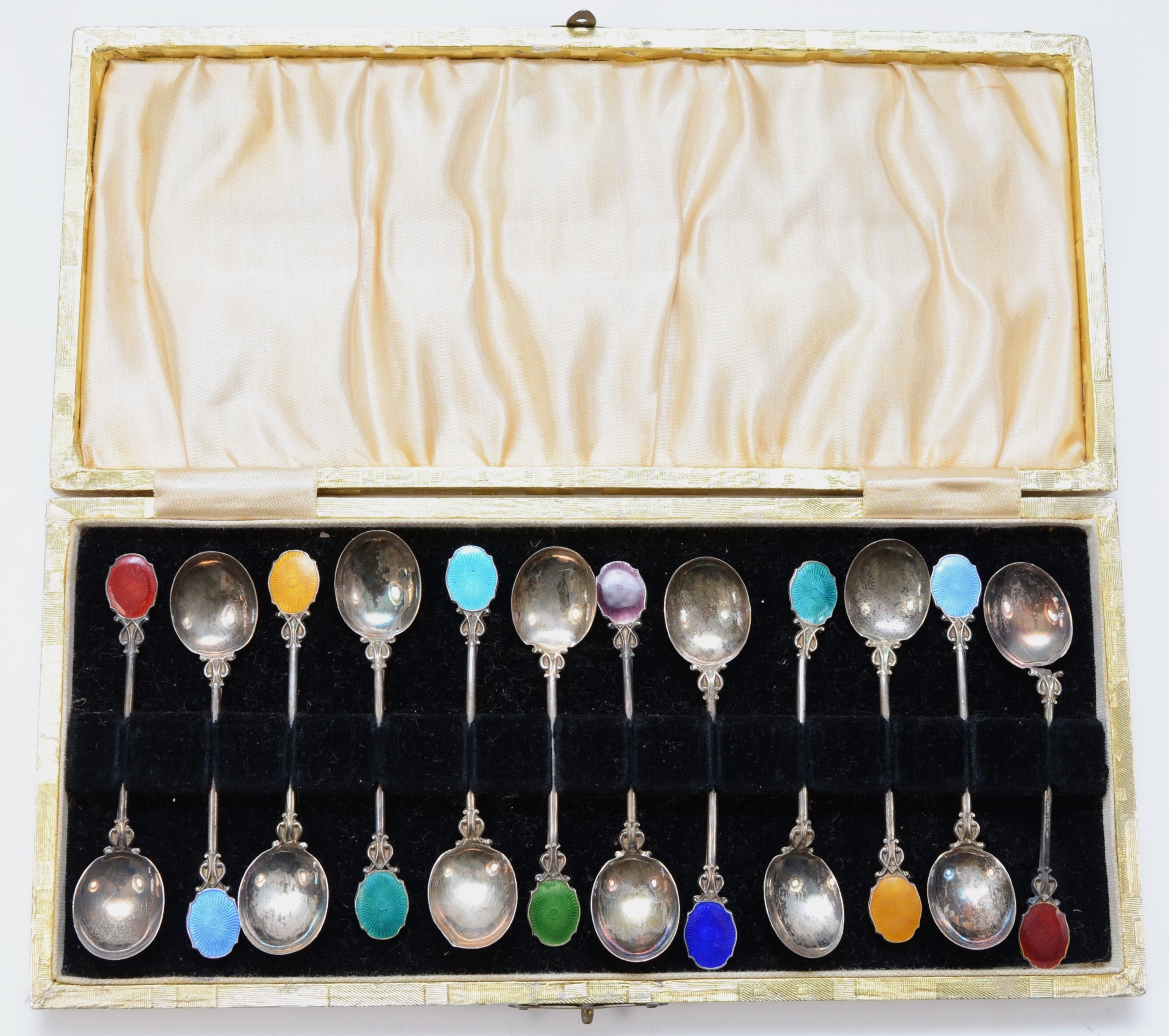 A set of twelve early 20th century continental silver and enamel tea spoons, cased, 60gm.