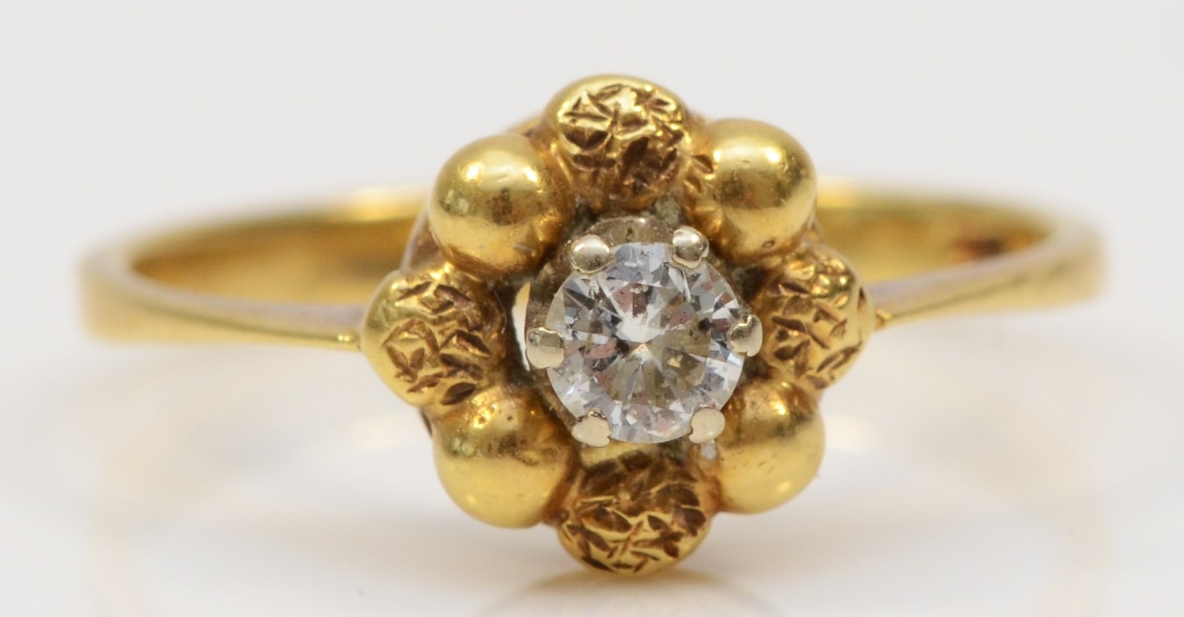 An 18ct gold single stone brilliant cut diamond floral ring, estimated weight .20, N, 2.9gm.