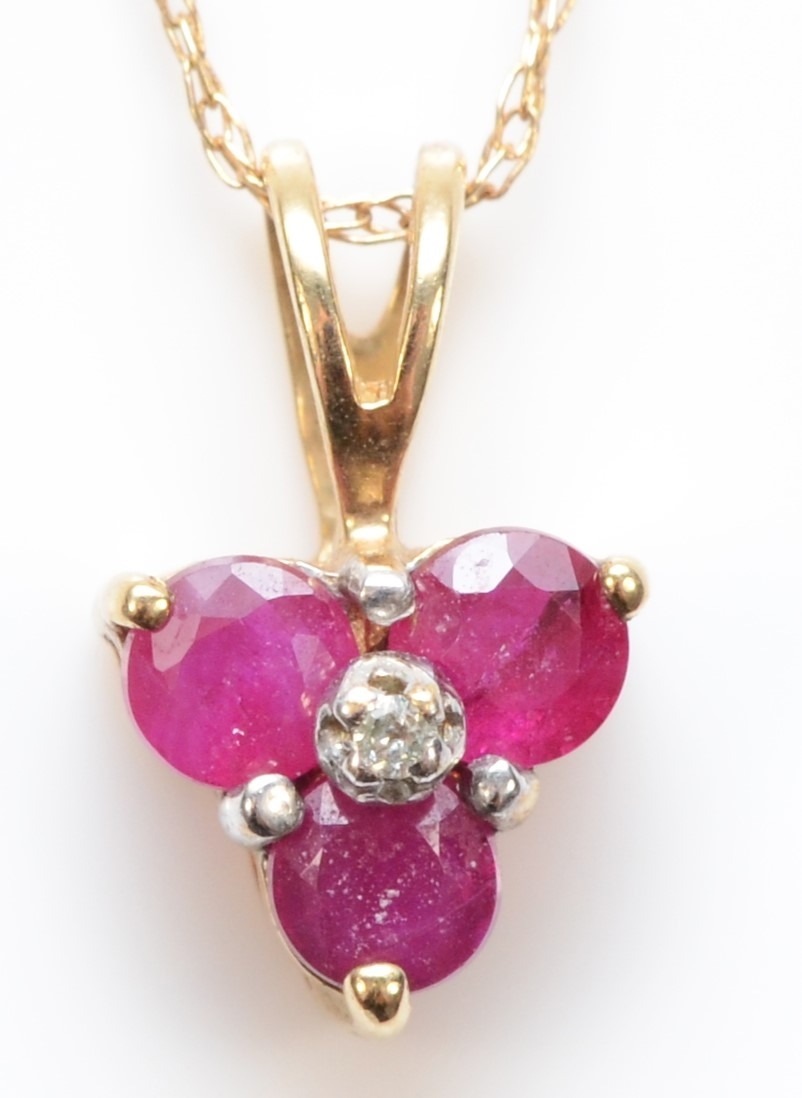 A 9ct gold ruby and eight cut diamond pendant, on a 375 gold chain, 11mm, .8gm.