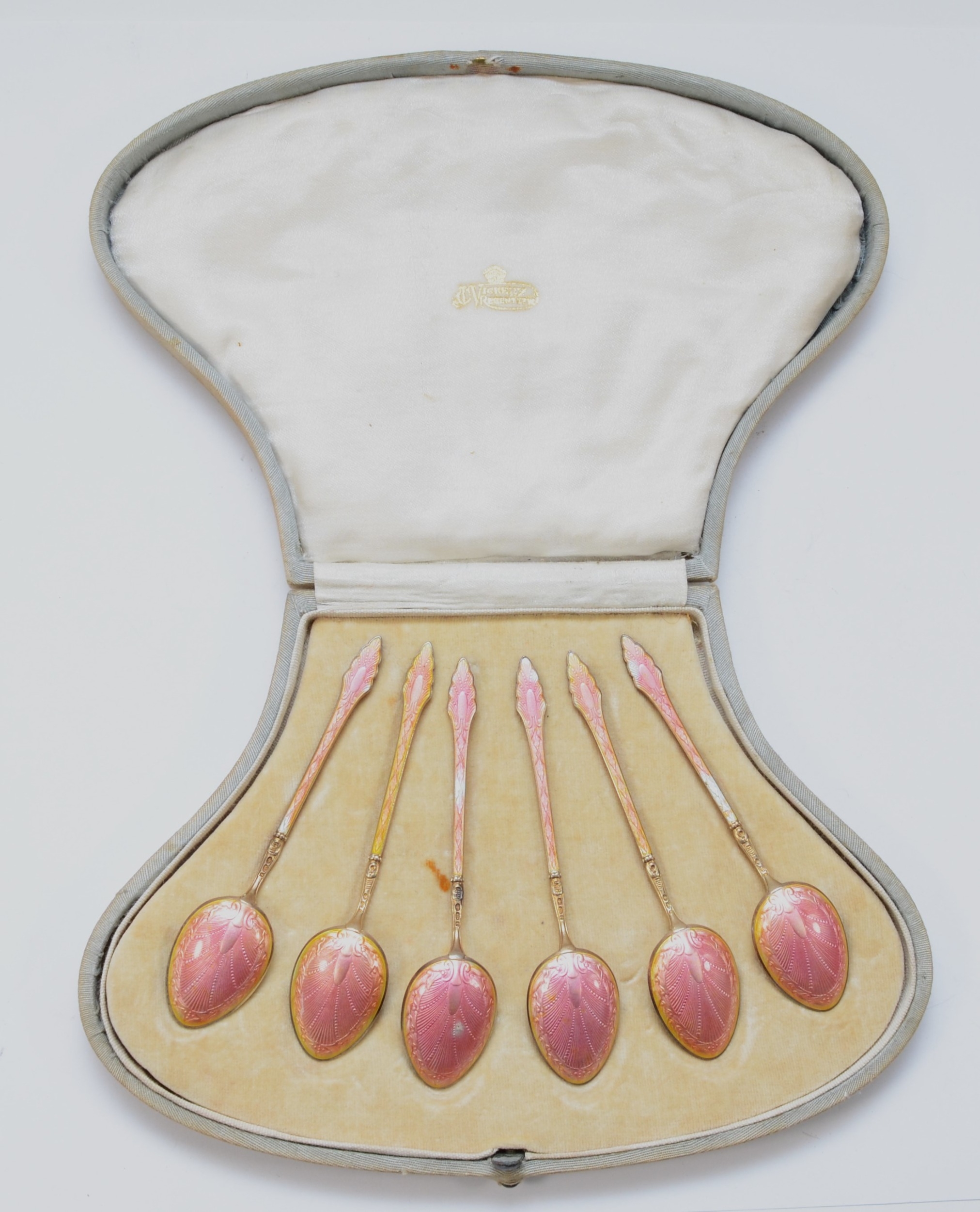 A set of Art Deco silver gilt and pink gouache enamel tea spoons, London import 1920, 65gm, cased.