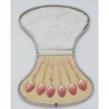 A set of Art Deco silver gilt and pink gouache enamel tea spoons, London import 1920, 65gm, cased.