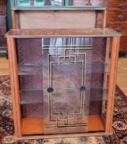 A 1950s glazed display cabinet, two sliding doors with adjustable glass shelves, H80, W67, D29.