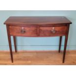A George IV mahogany bow fronted console table, having two deep drawers with brass swing handles,