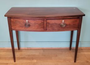 A George IV mahogany bow fronted console table, having two deep drawers with brass swing handles,