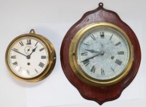 A 20th century ships brass bulkhead clock, having 8 day striking movement, mounted on a mahogany