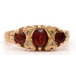 An Edwardian style 9ct gold garnet and diamond three stone ring, J, 1.7gm