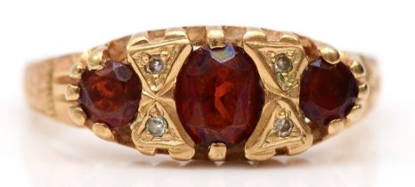 An Edwardian style 9ct gold garnet and diamond three stone ring, J, 1.7gm