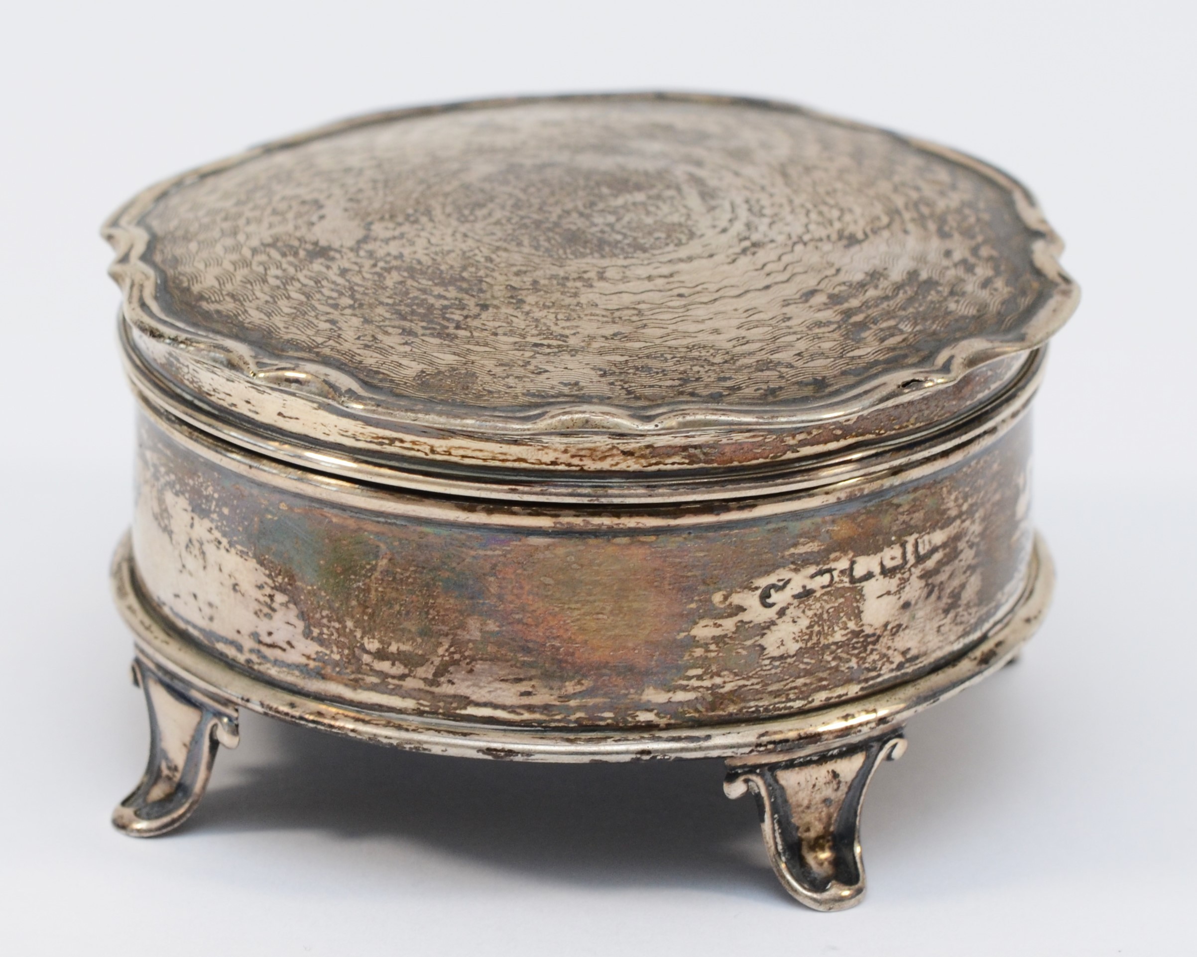 A silver trinket box, marks worn, Birmingham 1919?, hinged lid, raised on four legs, diameter 8cm