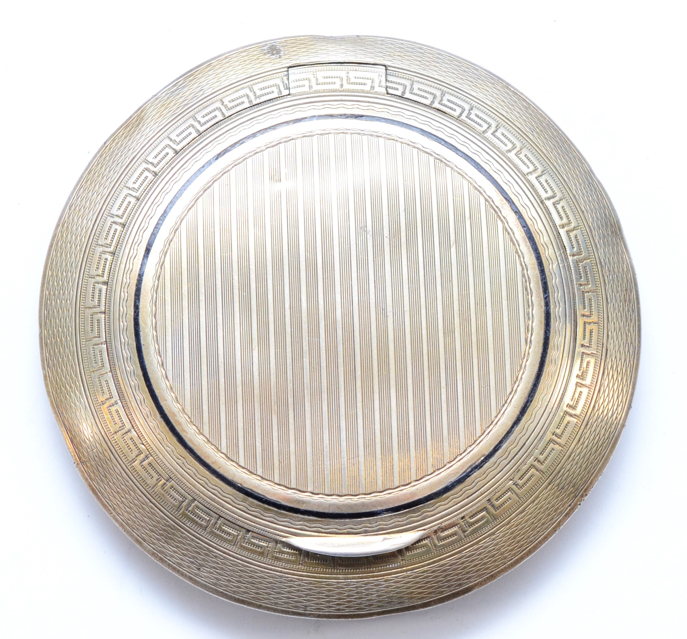 An Art Deco silver and black enamel compact, London import 1922, lacking interior, diameter 8.5cm,