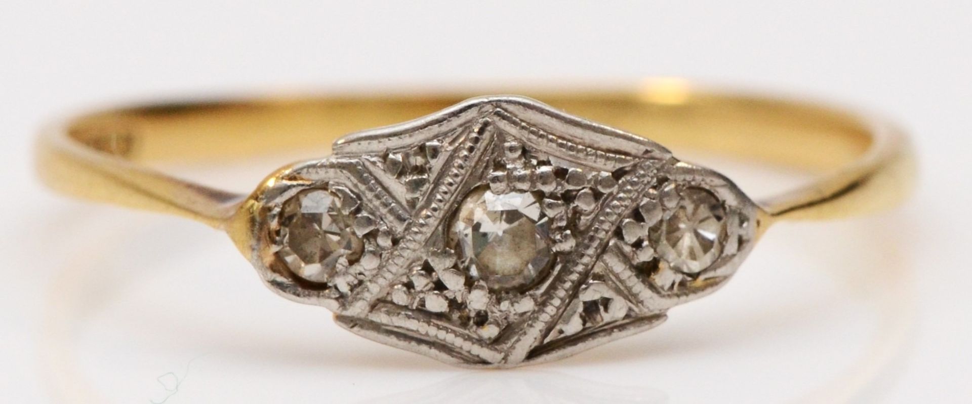 An Art Deco 18ct gold and platinum and diamond three stone ring, P 1/2, 1.4gm