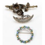 An unmarked silver and enamel wreath brooch, 33mm, a silver gilt rose brooch and a paste set