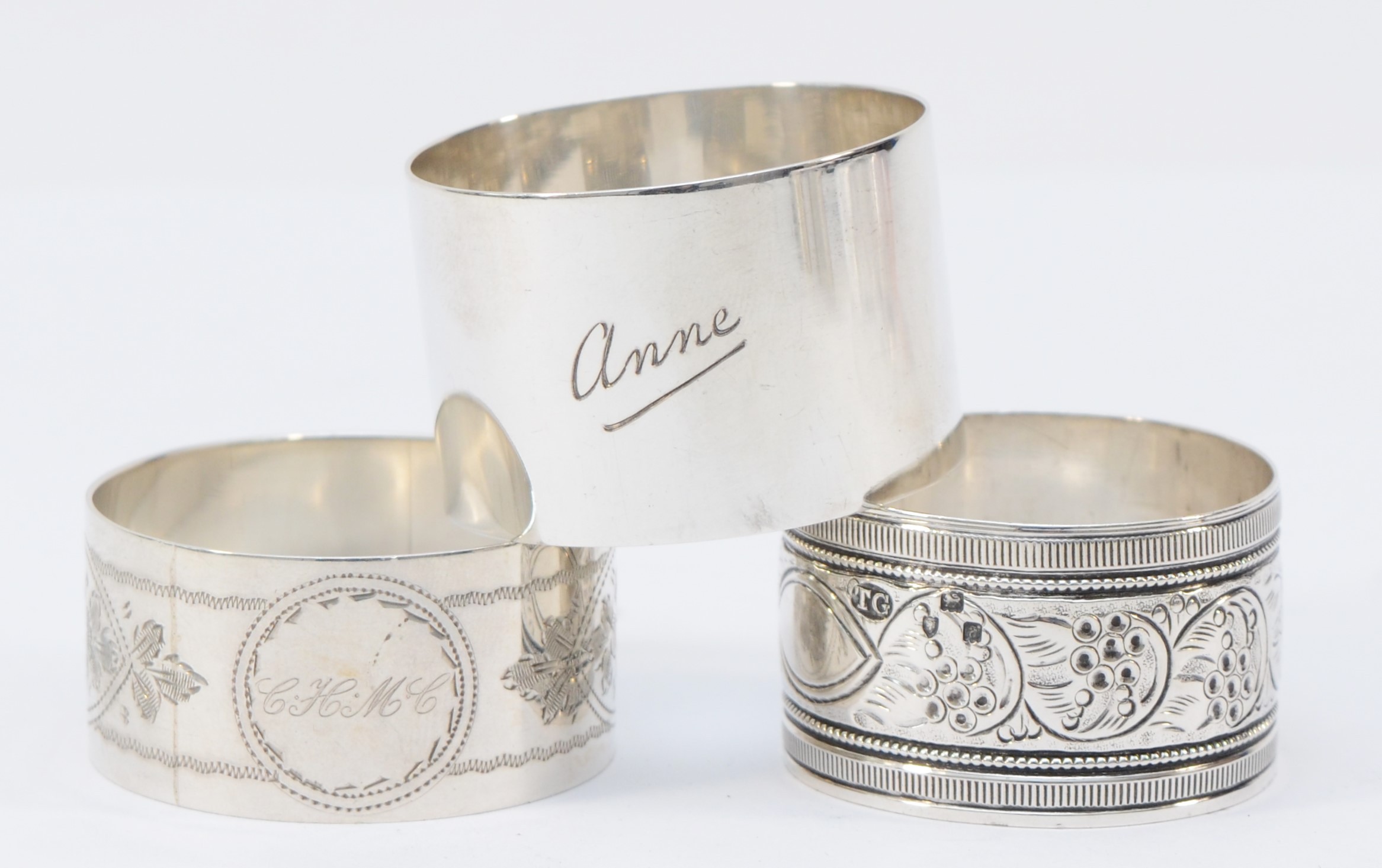 A silver napkin ring, by A.E. Jones, Birmingham 1917, inscribed Anne, and two other nakin rings,