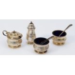 A four piece silver cruet set, Birmingham 1926, blue glass liners, two associated silver spoons,