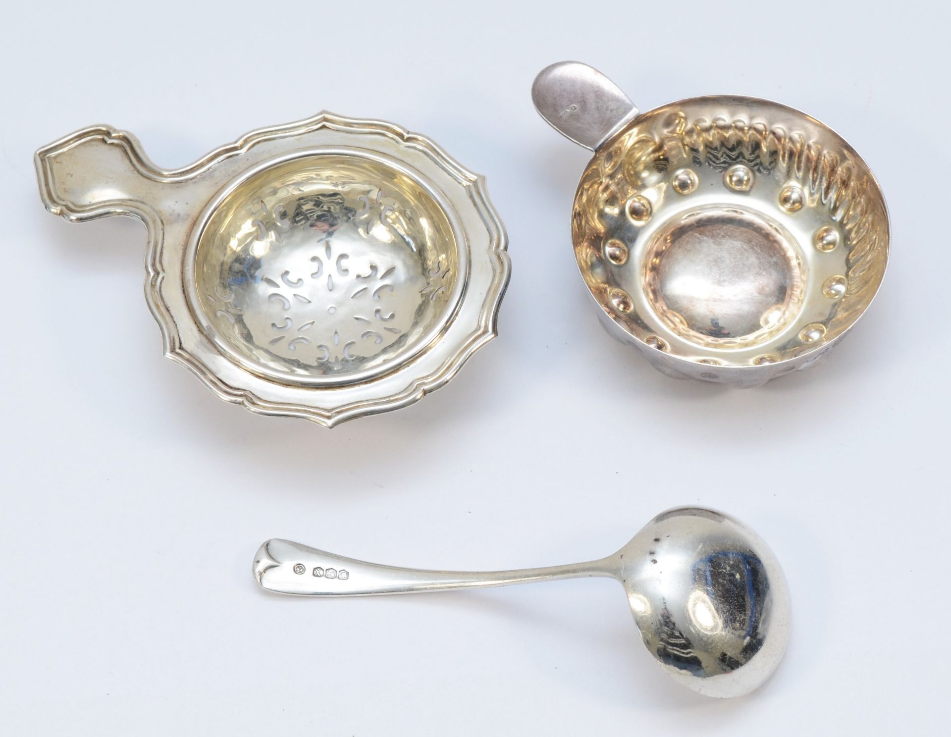 A silver tea strainer, London 1955, a silver sauce ladle, Sheffield 1965, 48gms and an electroplated - Image 2 of 2