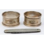 A pair of silver napkin rings, Birmingham 1932, both with E.M.B. initials and a metal Kings and