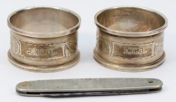 A pair of silver napkin rings, Birmingham 1932, both with E.M.B. initials and a metal Kings and