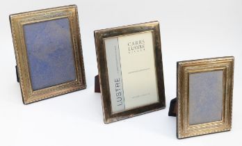 A silver photograph frame, Sheffield 1992, with embossed decoration, 22 x 17.5cm and two other