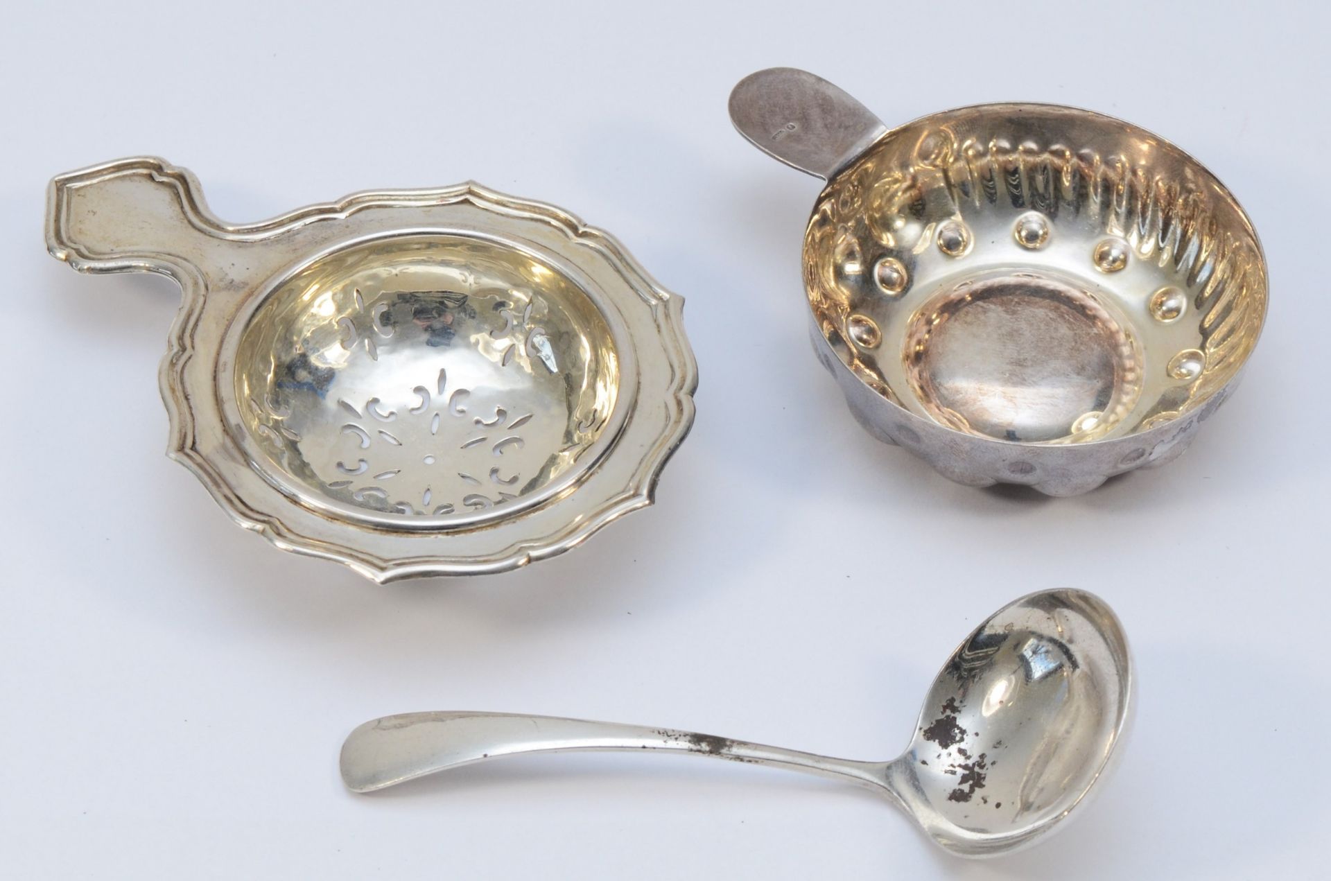 A silver tea strainer, London 1955, a silver sauce ladle, Sheffield 1965, 48gms and an electroplated