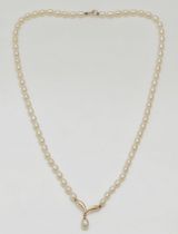 A single row cultured pearl necklace, with 9ct gold V motif, 40cm