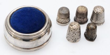 A silver pin cushion, Birmingham 1995, four silver thimbles and a Sterling Silver example
