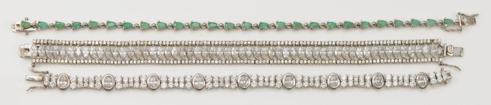 A silver and emerald set line bracelet, 20cm, and two other white stone set silver bracelets, 52gm
