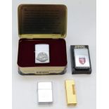 A Dunhill rollagas cigarette lighter, gold plated with engine turned case, together with three Zippo