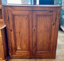 A late 19th century pitch pine kitchen cabinet, the twin panelled doors opening to reveal two fitted