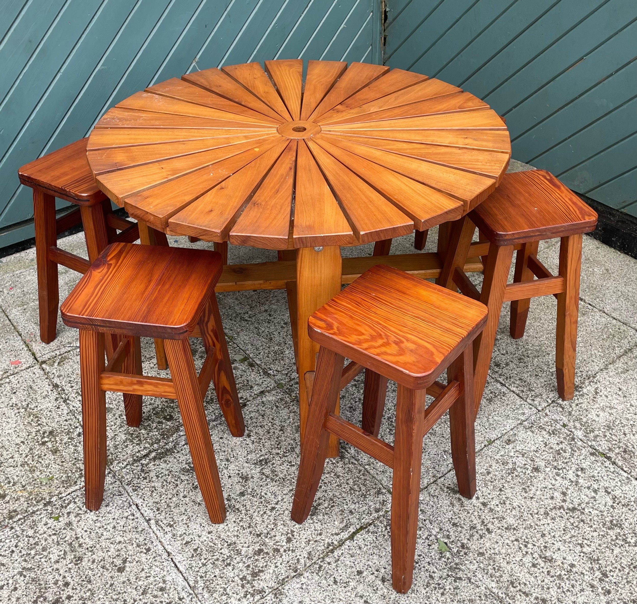 A child's pine garden table, 90cm diameter with six matching pine stools and a drum BBQ.