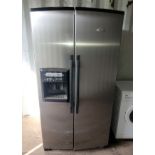 A modern Whirlpool fridge/freezer, brushed stainless steel, having built in water dispenser and