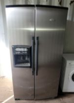 A modern Whirlpool fridge/freezer, brushed stainless steel, having built in water dispenser and