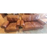 A contemporary two seater sofa upholstered in a grain tan hide leather, having drop in cushioned