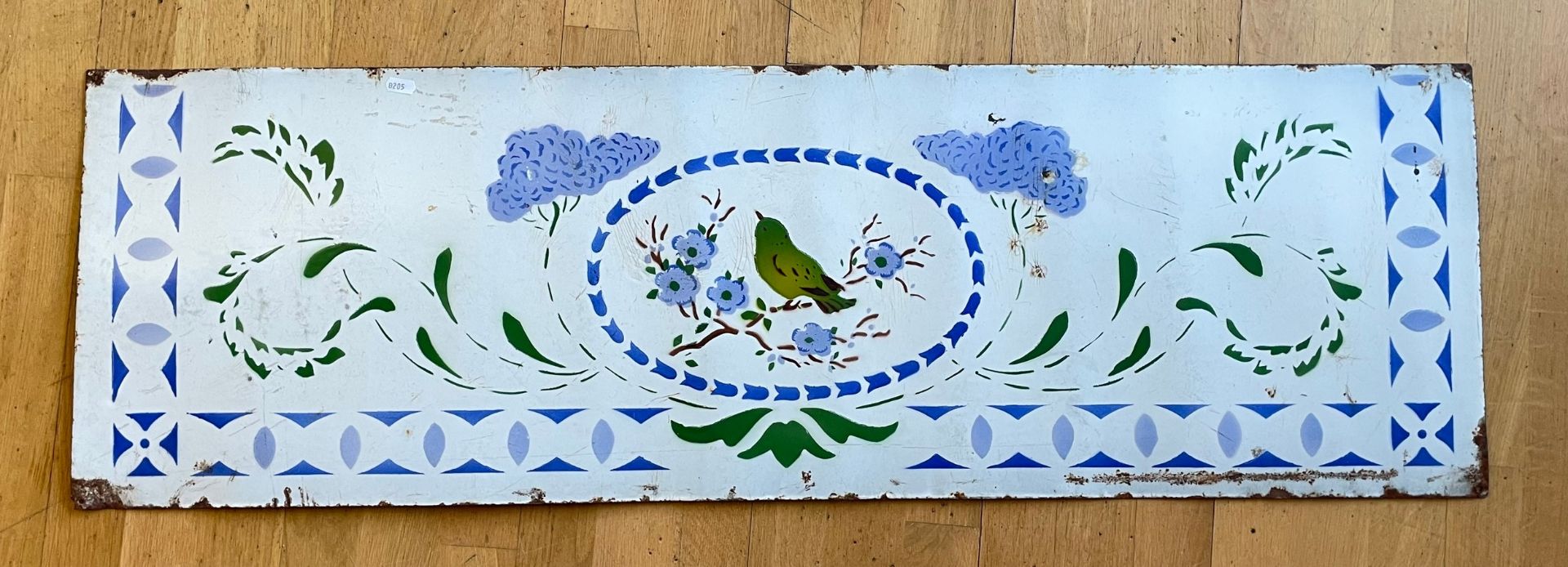 An early 20th century vitreous enamelled panel, depicting a bird amongst foliage. 122x38cm.