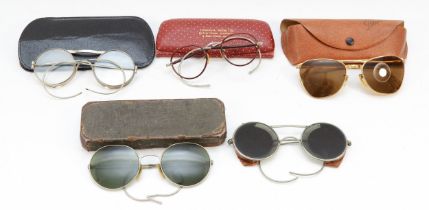 Two pairs of early 20th century sunglasses, together with a later Polaroid cased pair and two