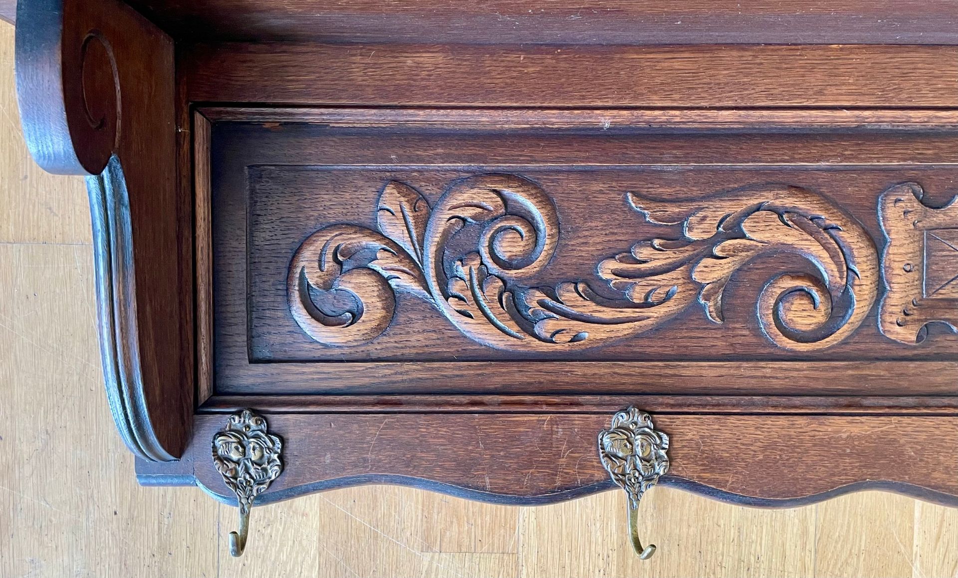 An early 20th century oak wall shelf, having carved frieze floral relief, with five brass hooks. - Image 2 of 3