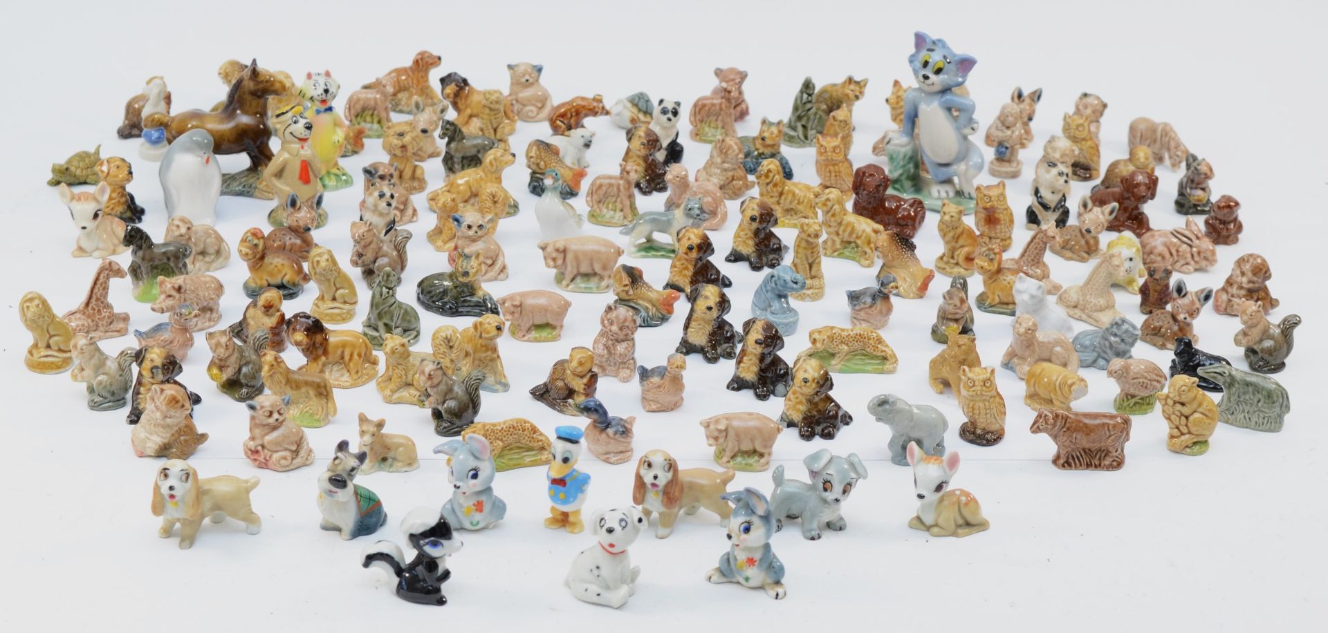 A large collection of Wade 'whimsies' porcelain figures and animal models, including Disney