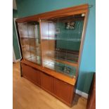 A matching pair of mid 20th century teak mirror back twin glass door display cabinets, each with