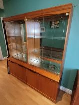 A matching pair of mid 20th century teak mirror back twin glass door display cabinets, each with