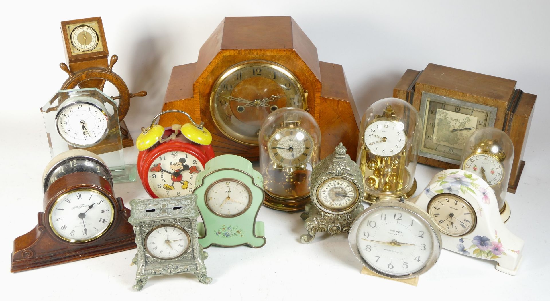 A collection of mid 20th century and later mantel clocks, alarm clocks and barometers, in three