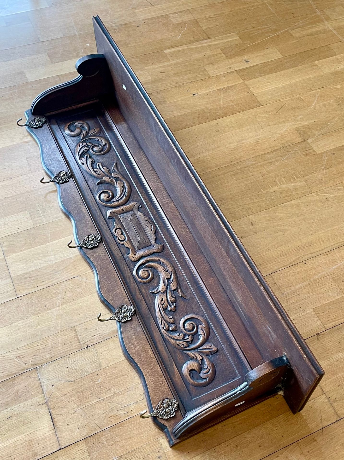 An early 20th century oak wall shelf, having carved frieze floral relief, with five brass hooks. - Image 3 of 3