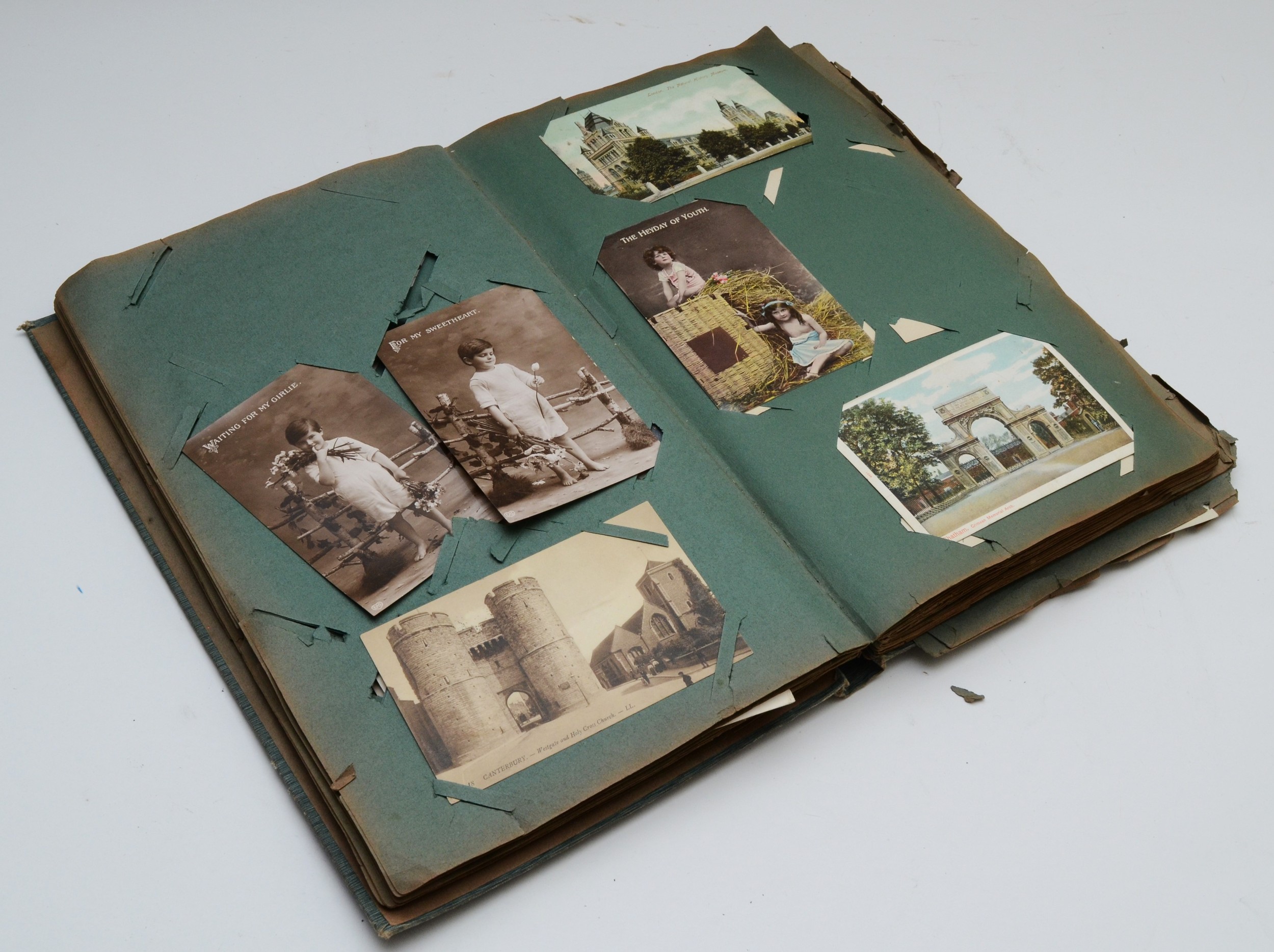 A postcard album and contents including over two hundred topical postcards, dating from early to mid