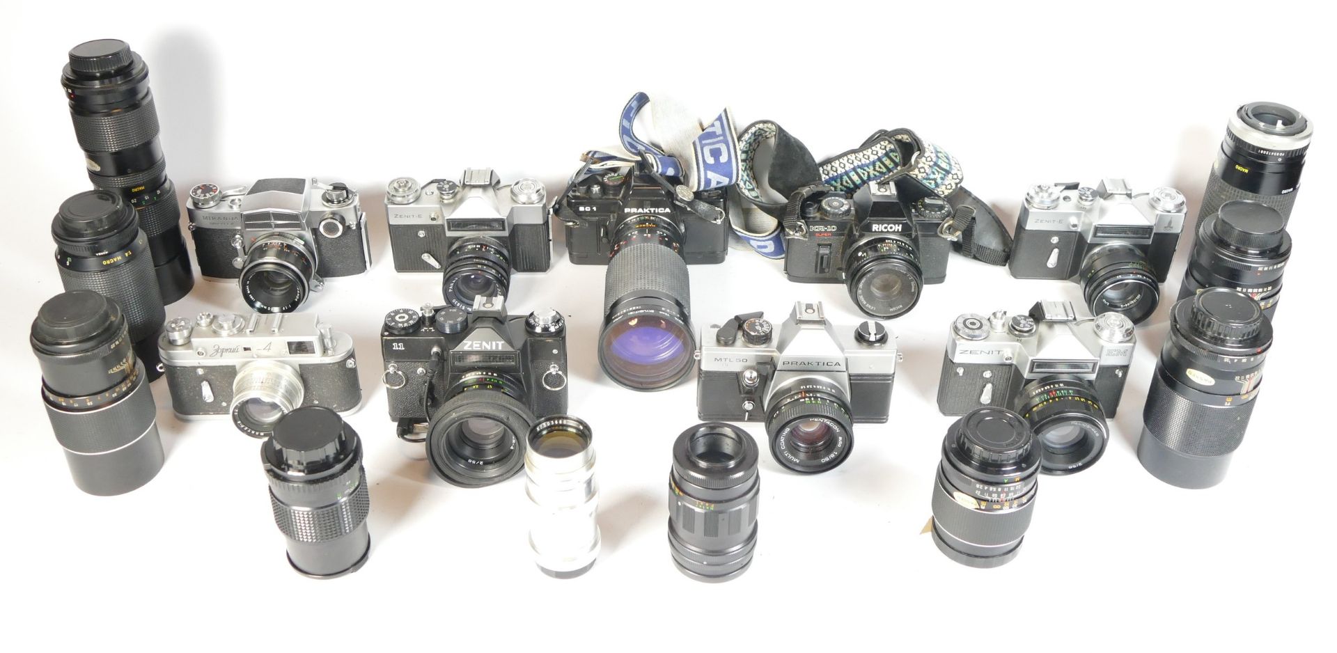 Eight SLR vintage film cameras to include a Zenit E, a Praktica BC1, a Ricoh KR10 and a Zenit II.