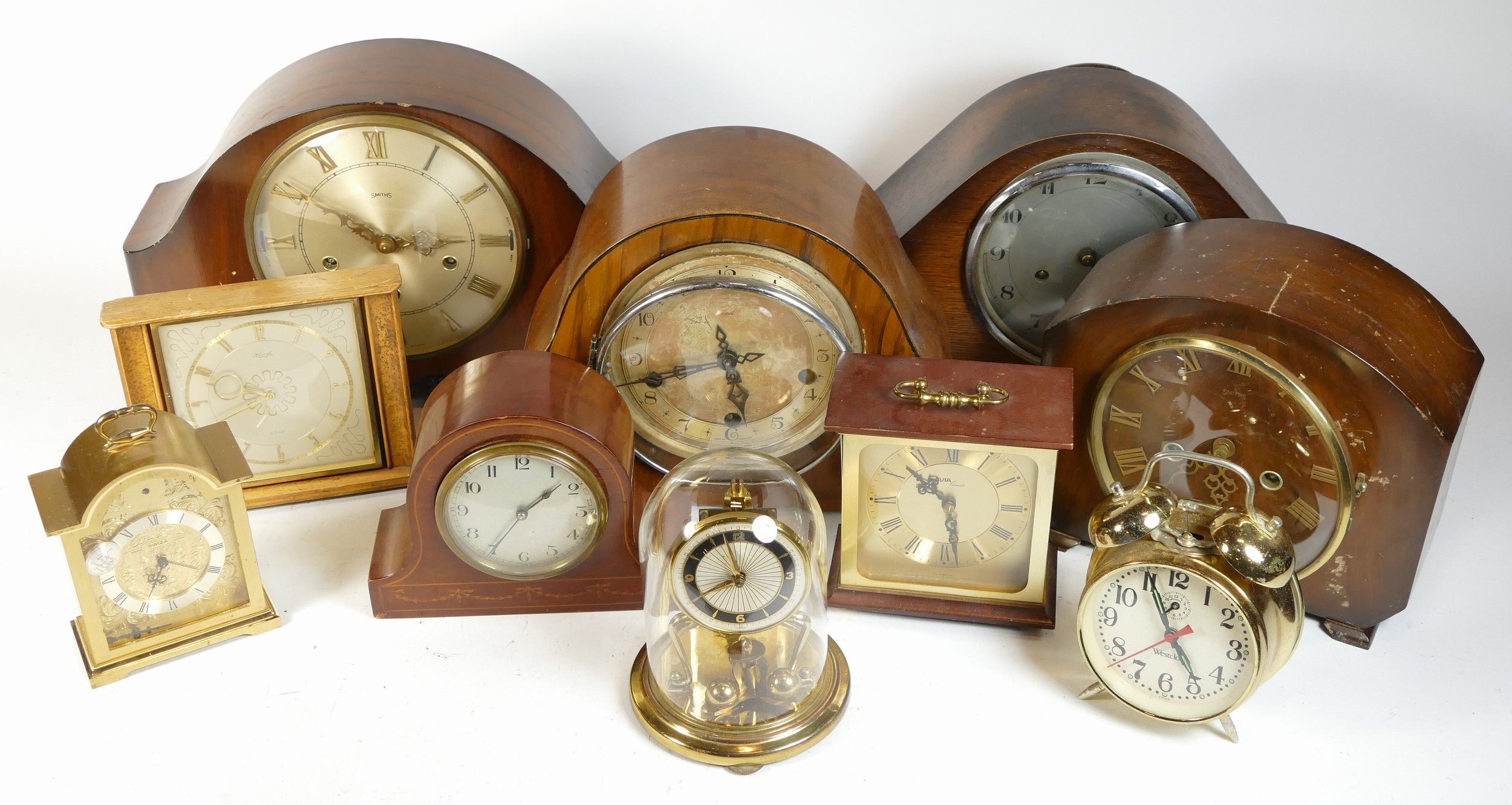 A collection of mid 20th century and later mantel clocks, alarm clocks and barometers in three