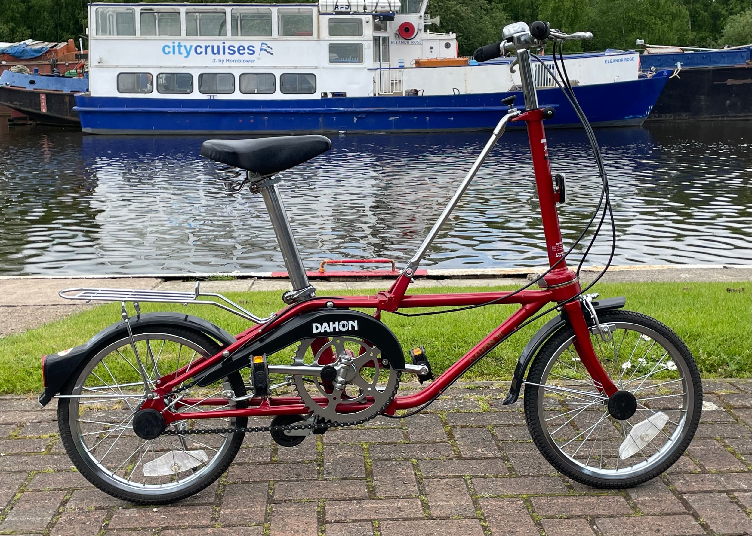 A Dahon folding bicycle, metallic red with carry case.