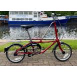 A Dahon folding bicycle, metallic red with carry case.
