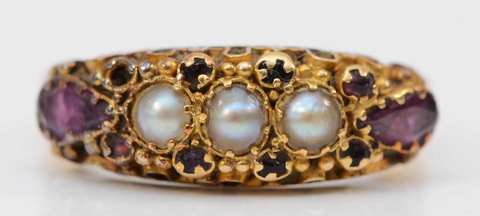 A Victorian 18ct gold amethyst and pearl ring, London 1860, with scroll mount and floral engraved